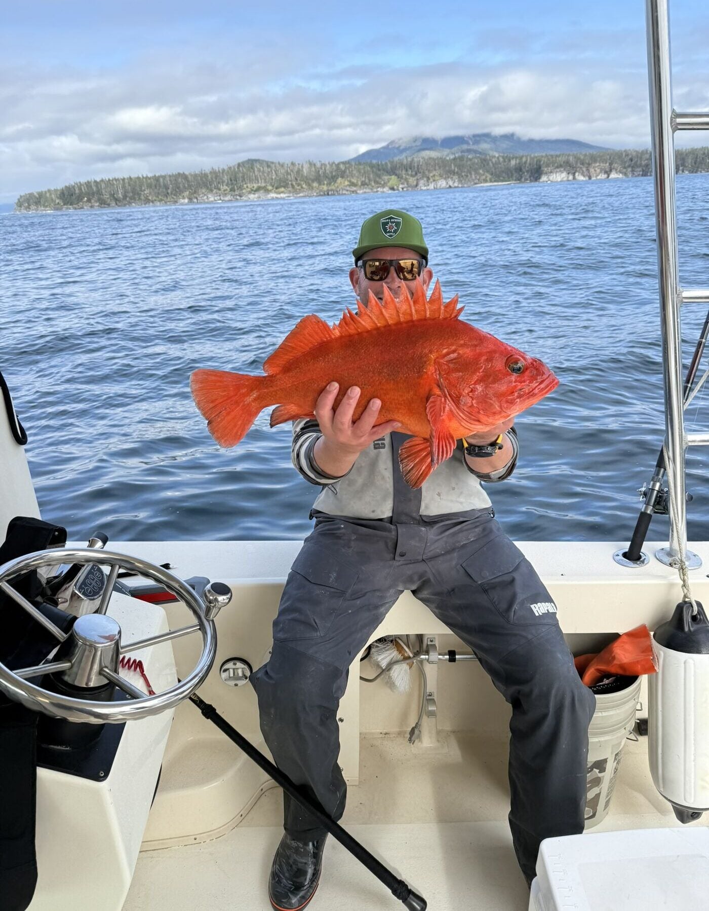 Jason Melschau holding a rockfish on a boat off the Pacific coast.