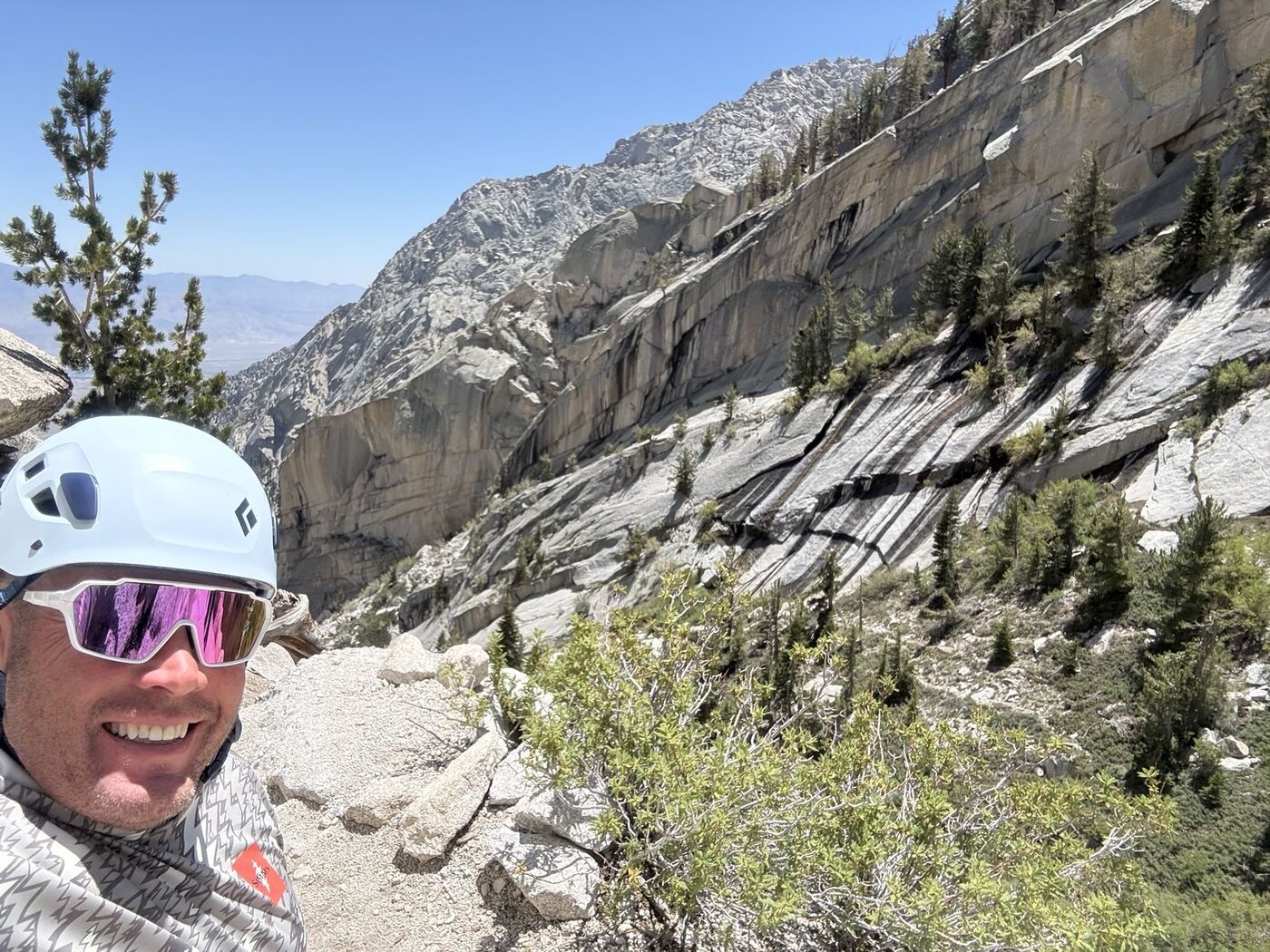 Jason Melschau in a climbing helmet on a granite ridge in the Sierra.